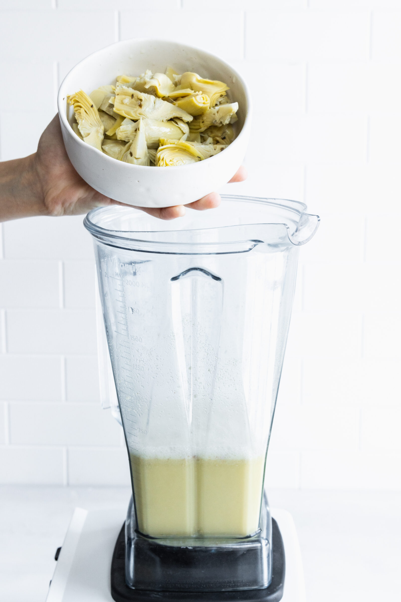 Adding artichoke hearts to the blender