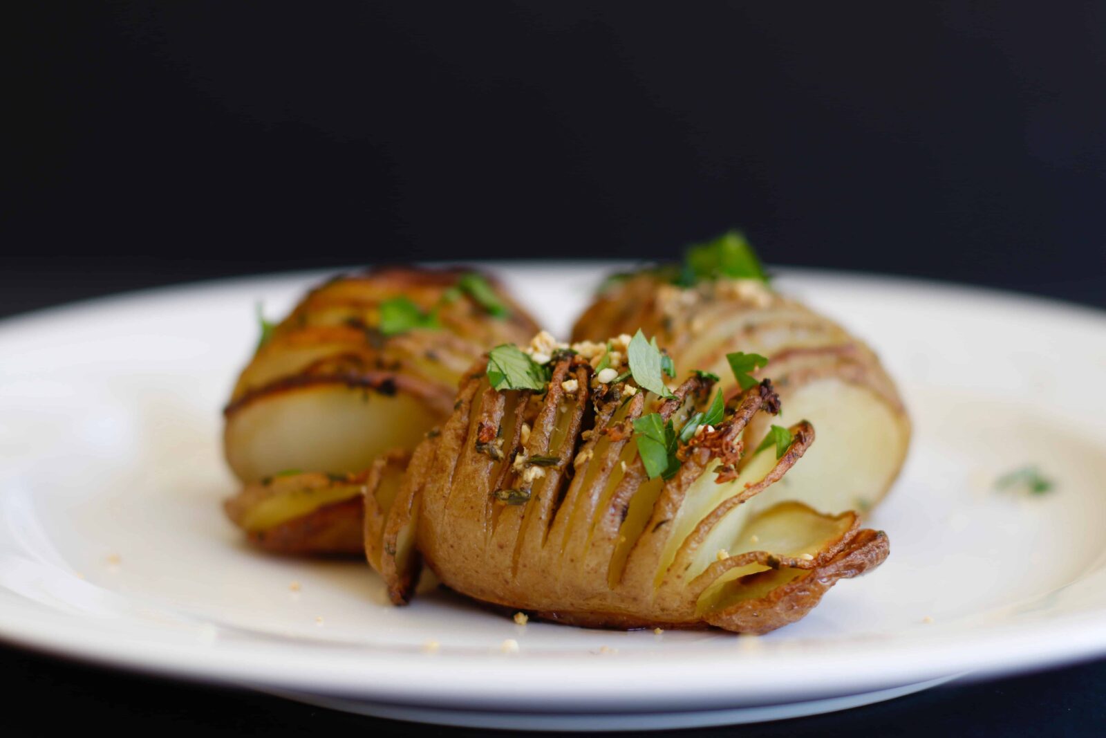 Hasselback Potatoes served on a white plate