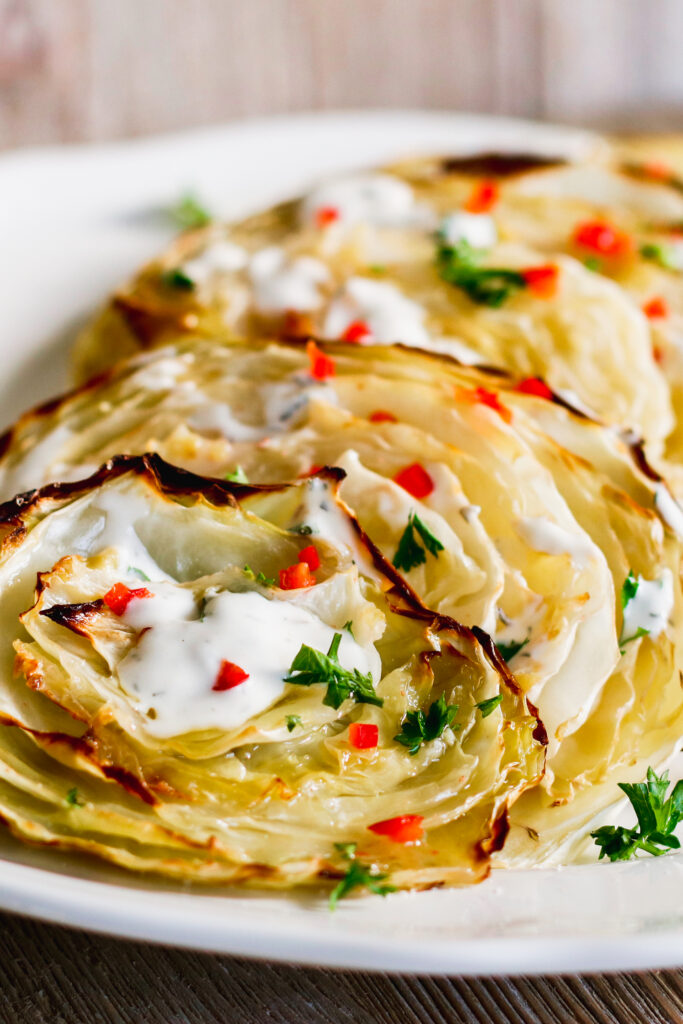 Cabbage Steaks served on a white plate with Creamy Italian Dressing