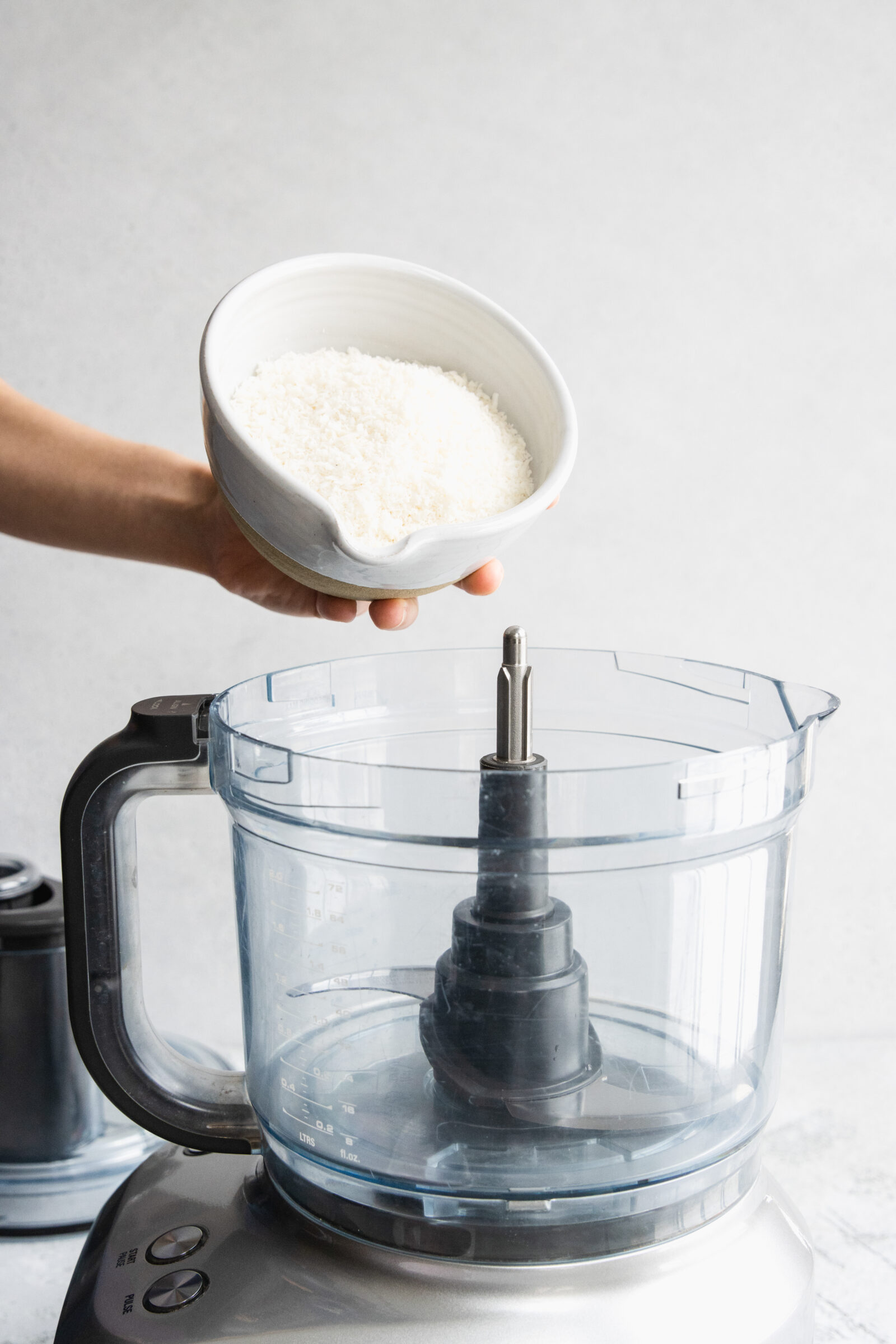 Adding shredded coconut to a food processor