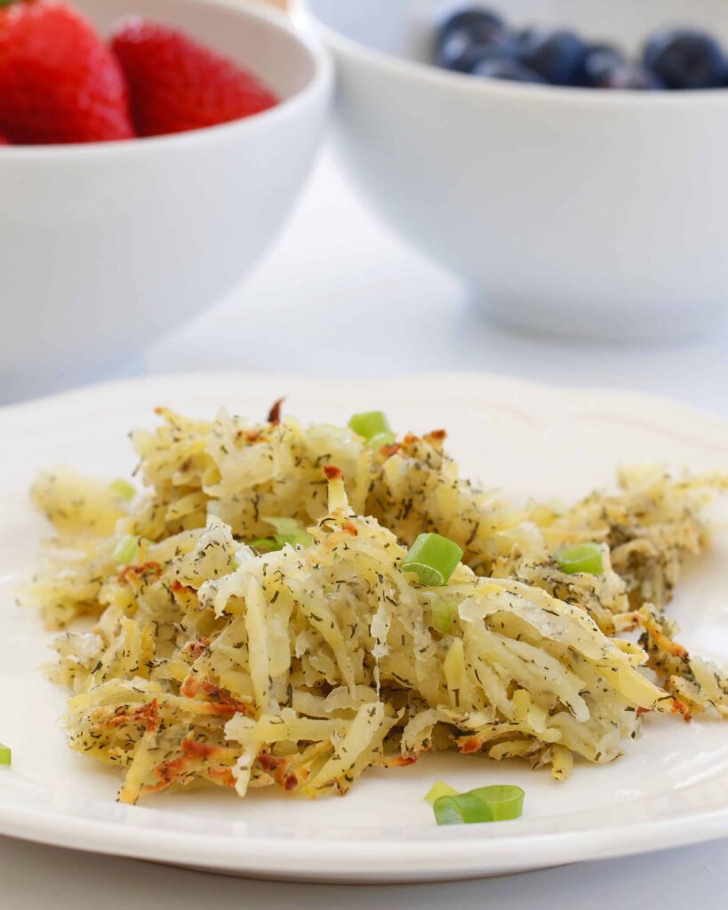 Hash Browns served on a white plate with green onion garnish. 