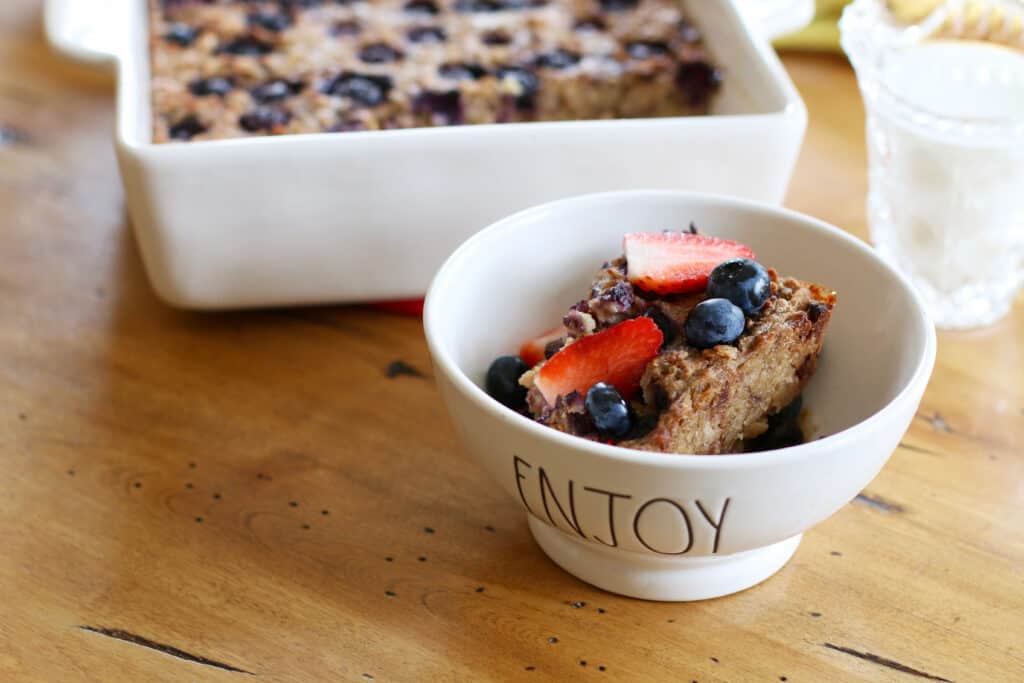 Vegan Overnight Baked Oats served in a bowl with fresh strawberries and blueberries 