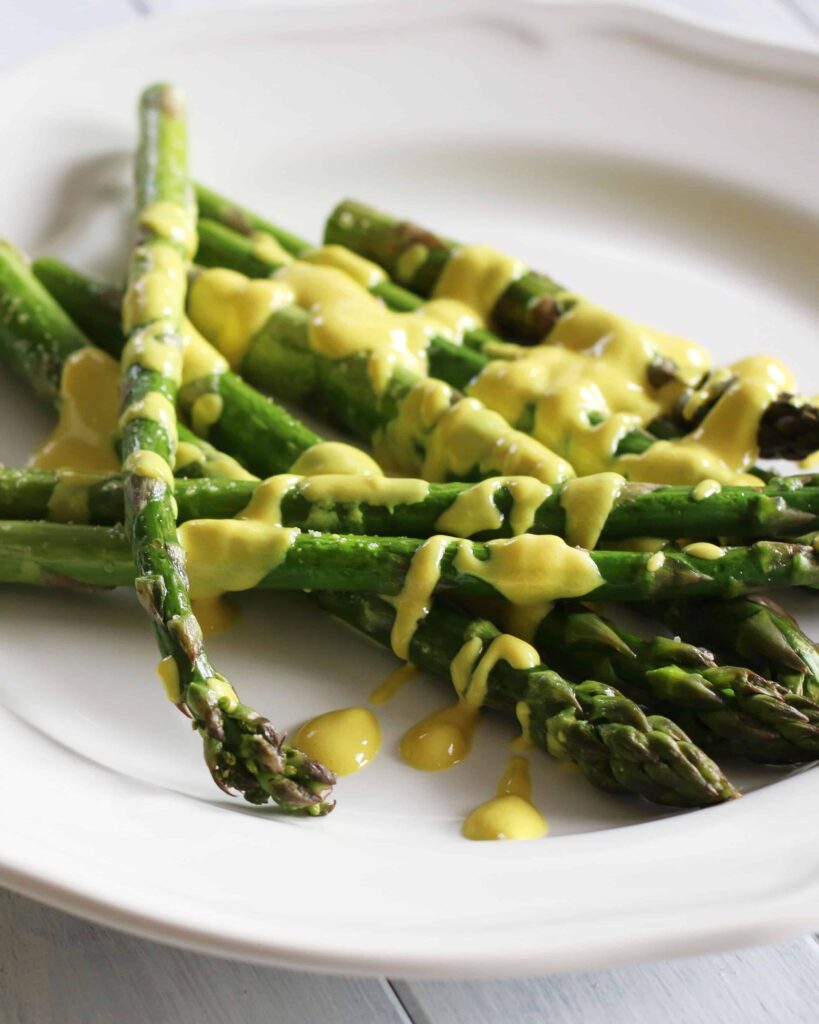 Roasted Asparagus with Vegan Hollandaise Served on a white plate