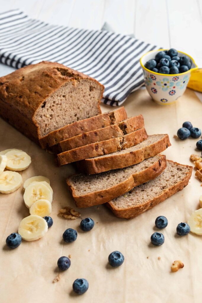 Vegan Banana Bread sliced and served with fresh blueberries