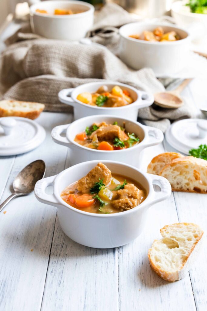 Vegan "Beef" Stew served in 3 white bowls.