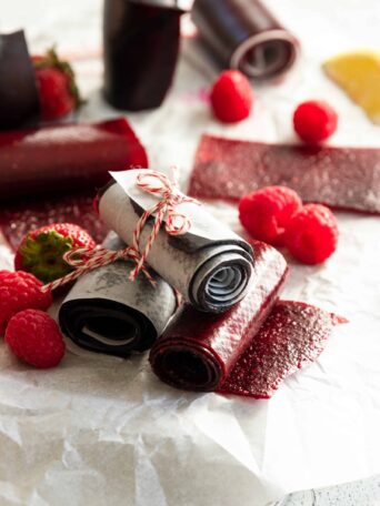 Homemade Fruit Leather rolled up with fresh fruit