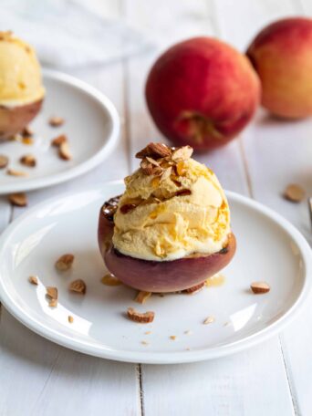 Grilled Peaches with Vegan Peach Ice Cream Served on a White Plate
