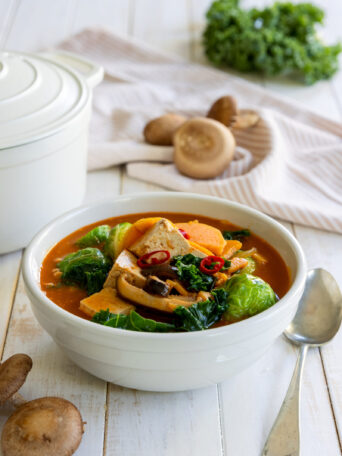 Fall Sweet Potato Kale Coconut Curry Soup in a white bowl with a spoon