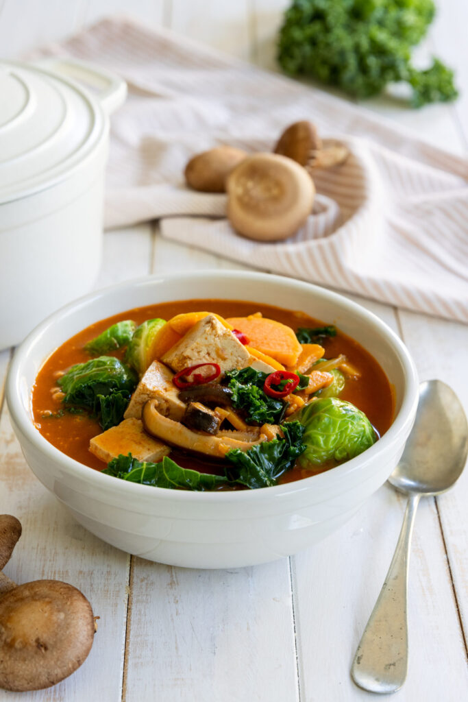 Fall Sweet Potato Kale Coconut Curry Soup on a bowl with a spoon