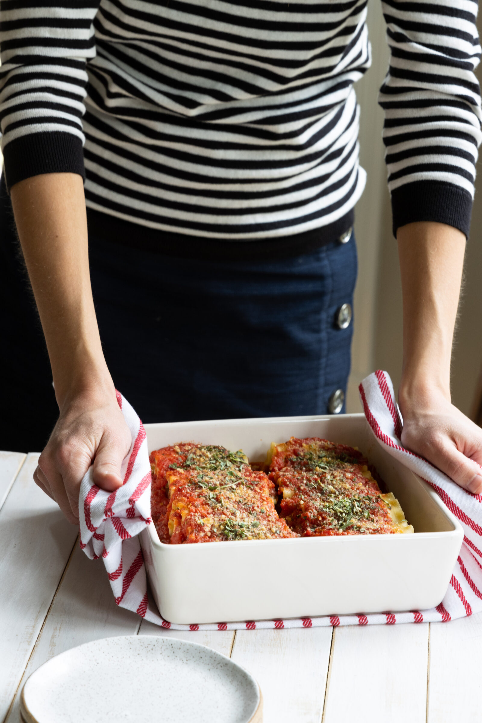 Chef Ani holding a pan of Lasagna Roll Ups with Vegan Ricotta and Spinach