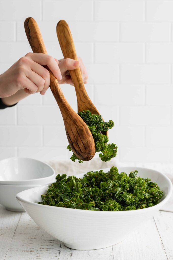 Sesame Kale Salad in a White Bowl with Tongs