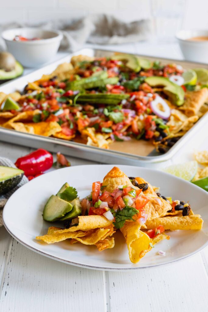 Vegan Sheet Pan Nachos served on a plate with vegan nacho cheese sauce made from cashews