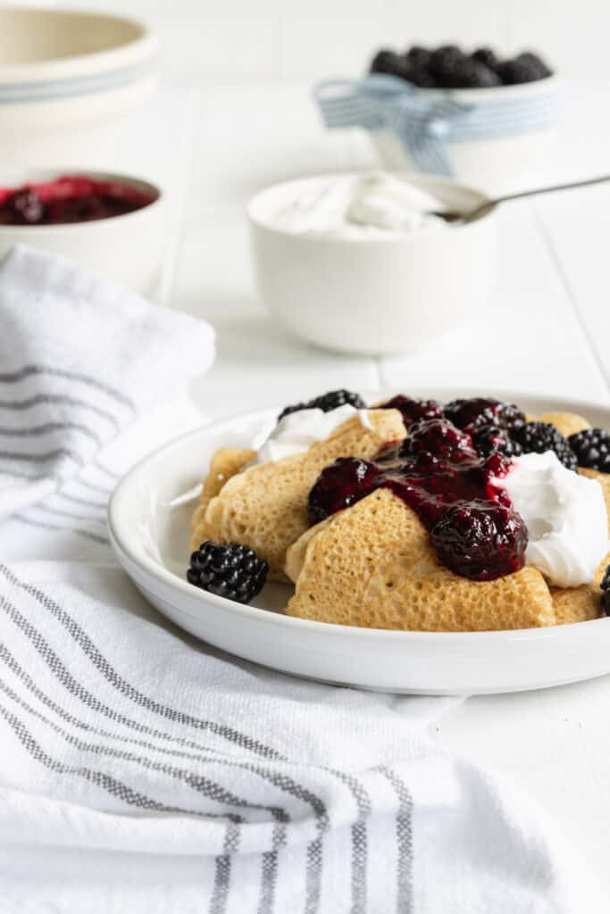 Crepes with Lemon Cream Cheese and Blackberry Filling served on a white plate