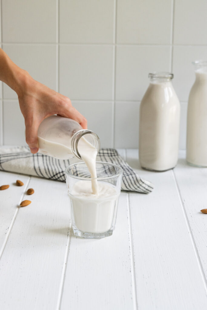 Easy homemade almond milk being poured into a glass