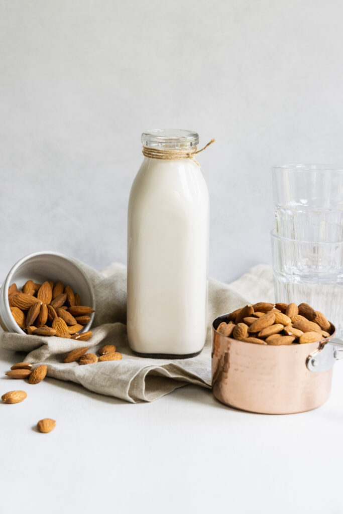 Easy homemade almond milk in a milk container with almonds