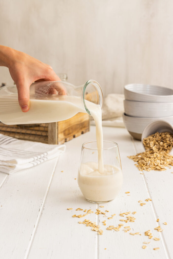 Pouring Fresh Homemade Oat Milk into a Glass