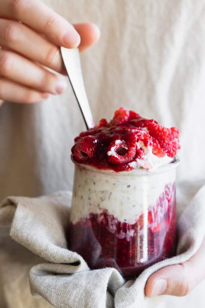 Hands holding a jar of overnight oats