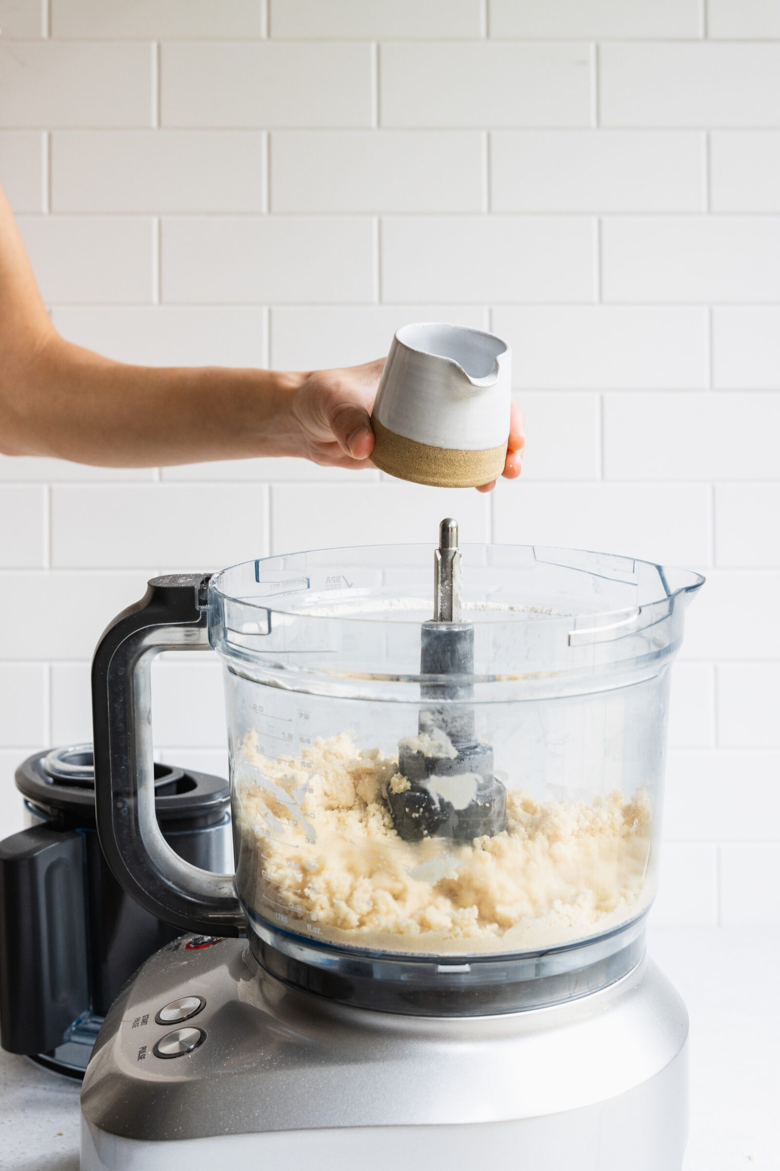 Adding ice water to the food processor