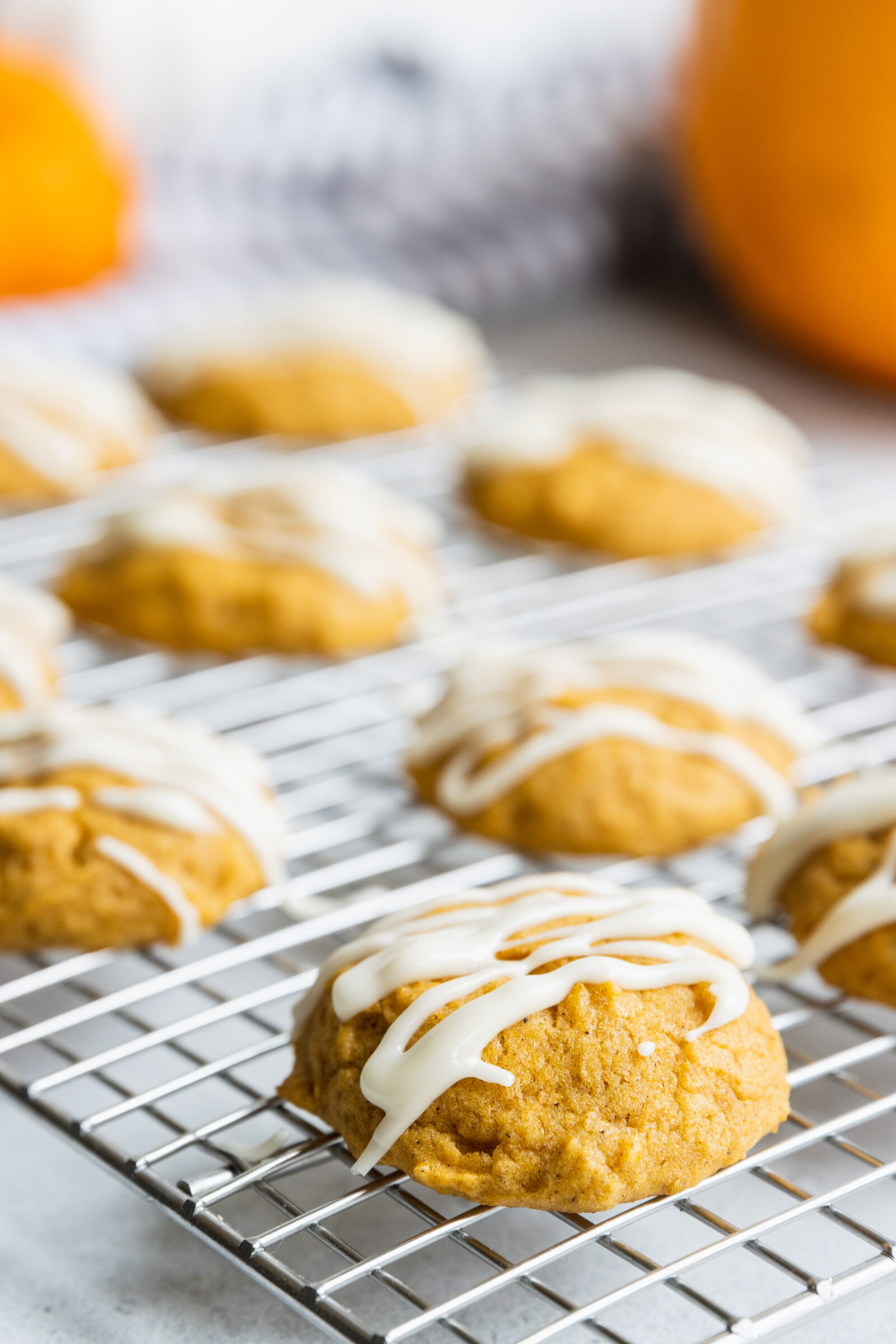 Vegan pumpkin cookies with maple frosting on a cooling rack