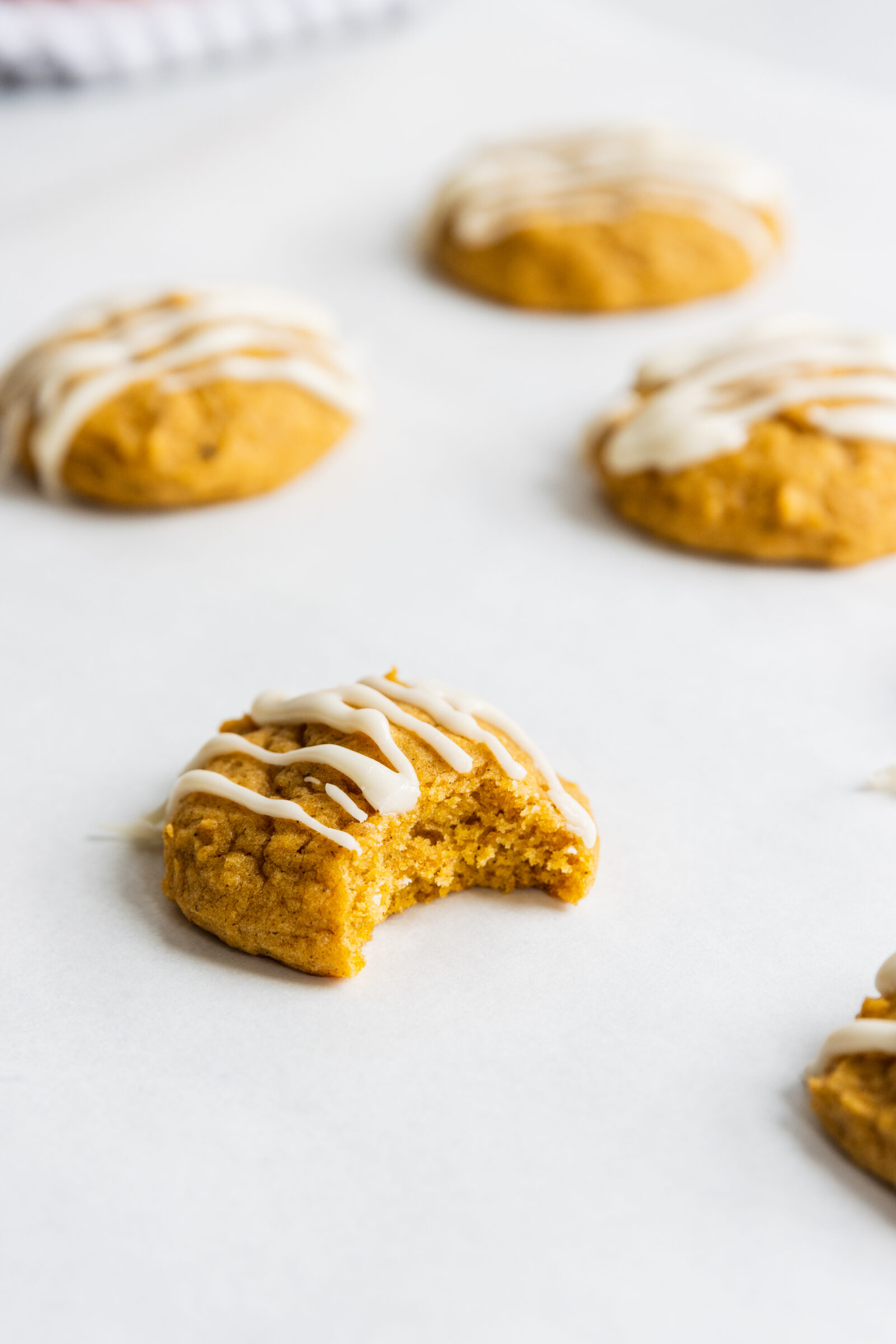 A vegan pumpkin cookie with a bite taken out of it