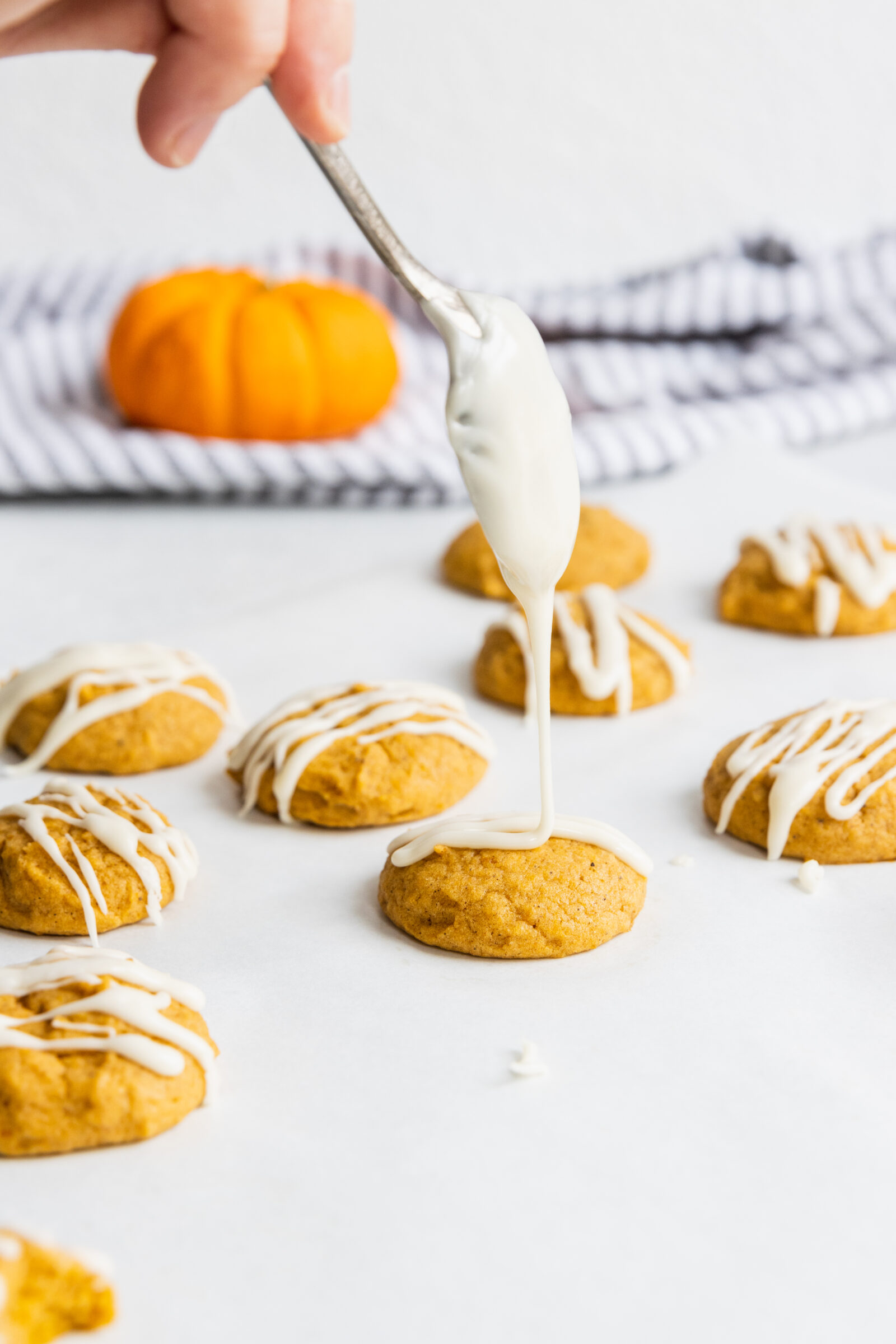 Drizzling maple glaze over the vegan pumpkin cookies