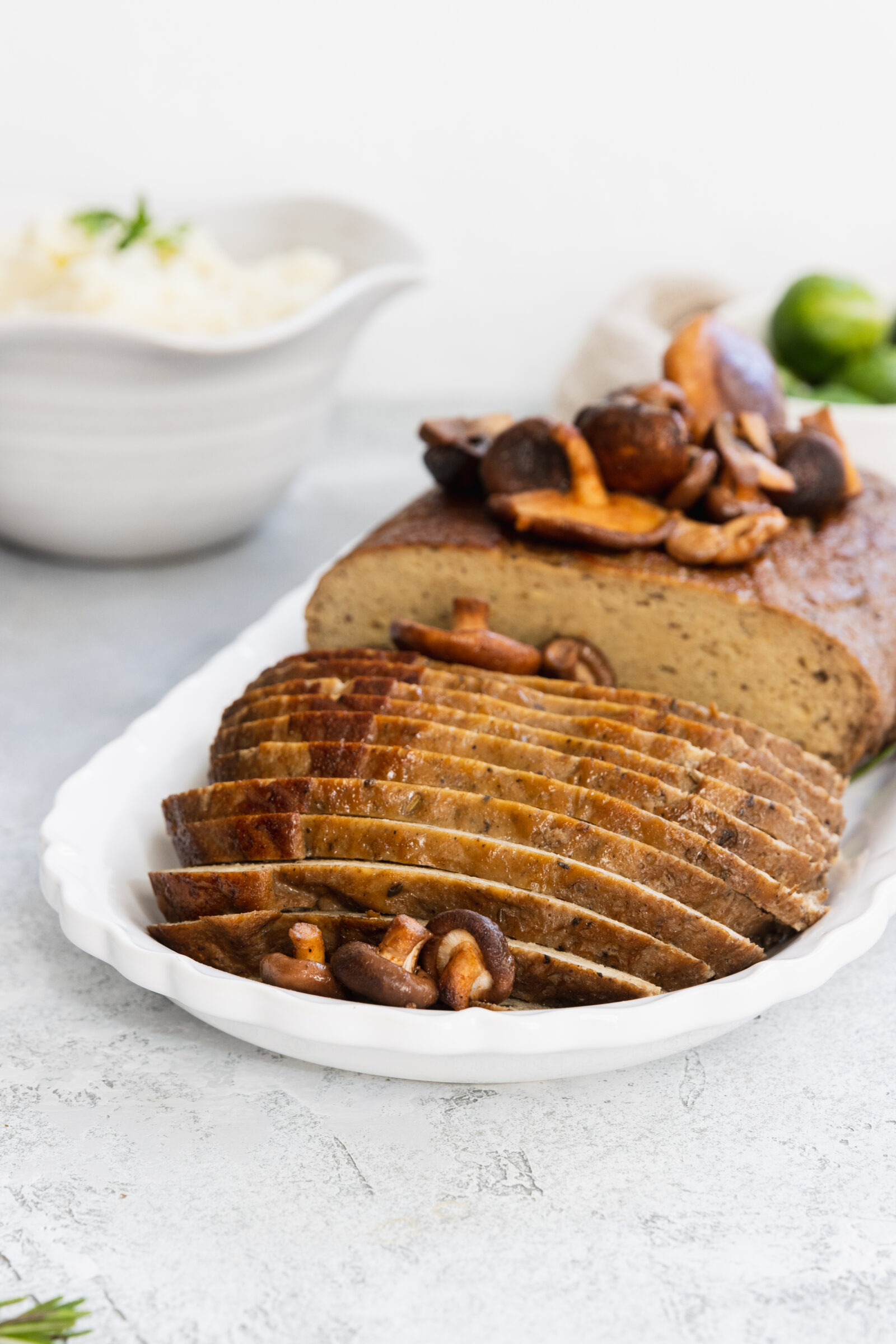 Plant-based turkey roast served on a platter with shiitake mushrooms