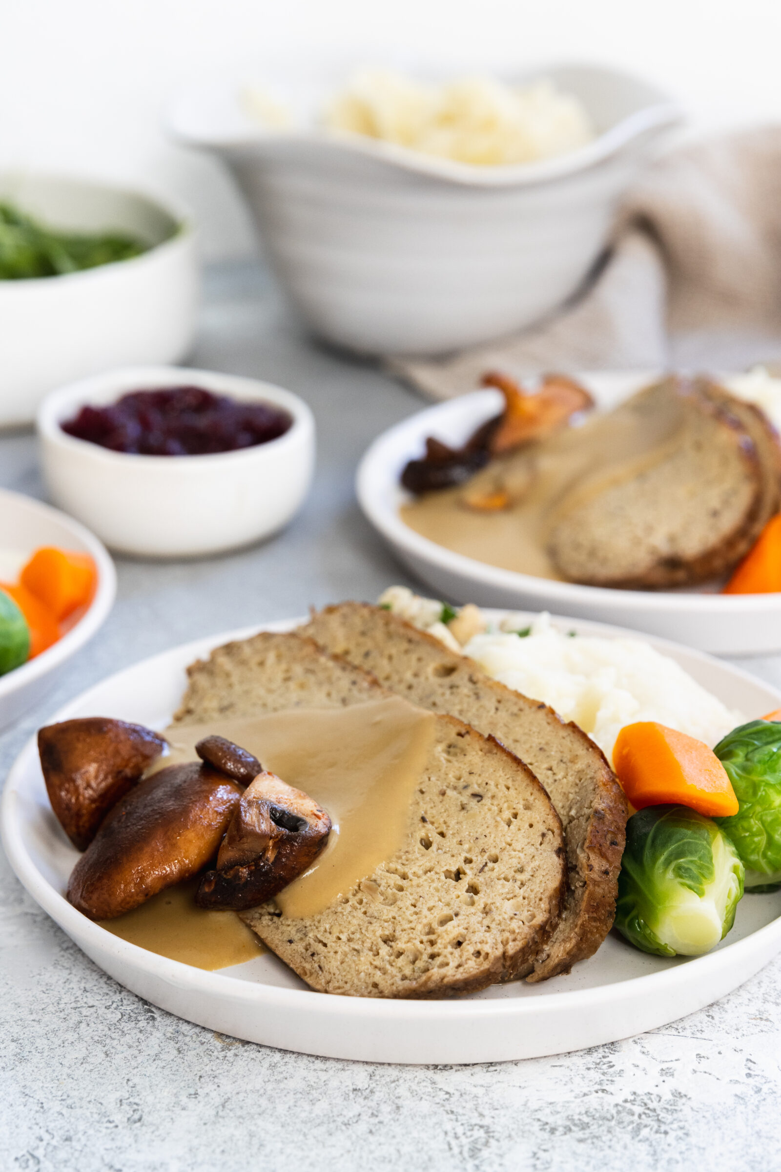 Slices of vegan turkey roast served with mashed potatoes and vegan gravy