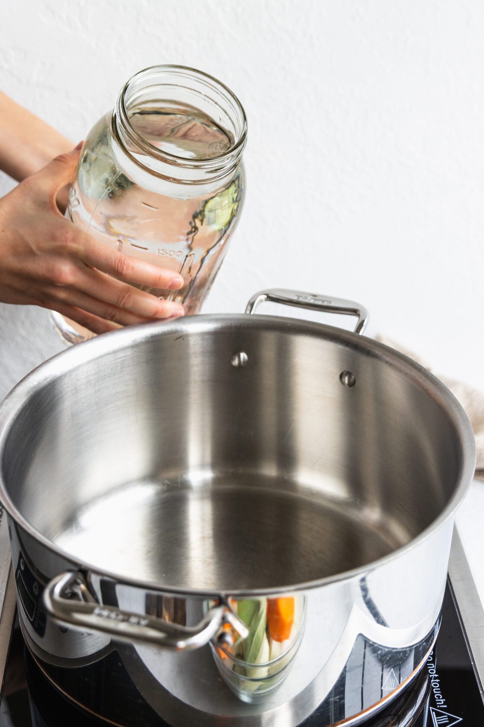 Adding water to a big pot to make the broth