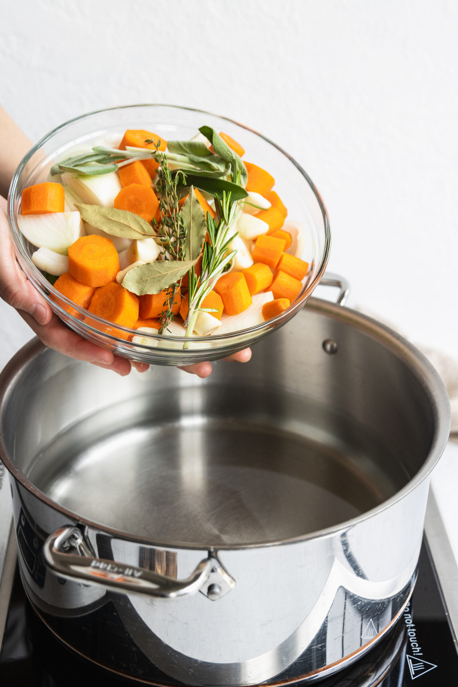 Making our broth by adding vegetables and herbs to a pot