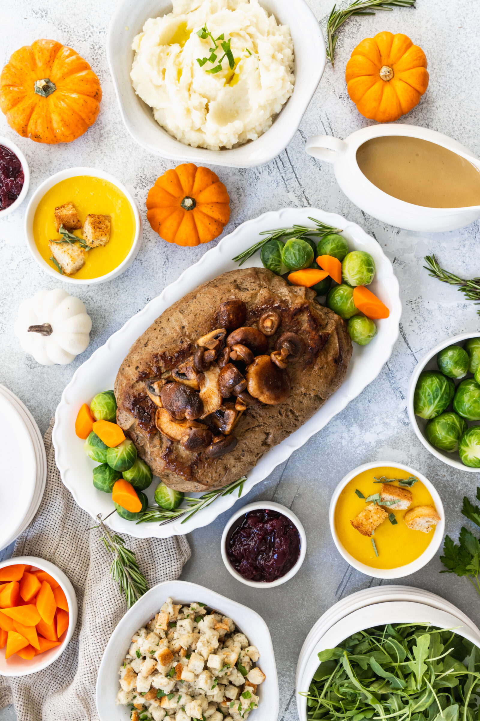 Vegan turkey roast served on a platter in the middle of the Holiday table