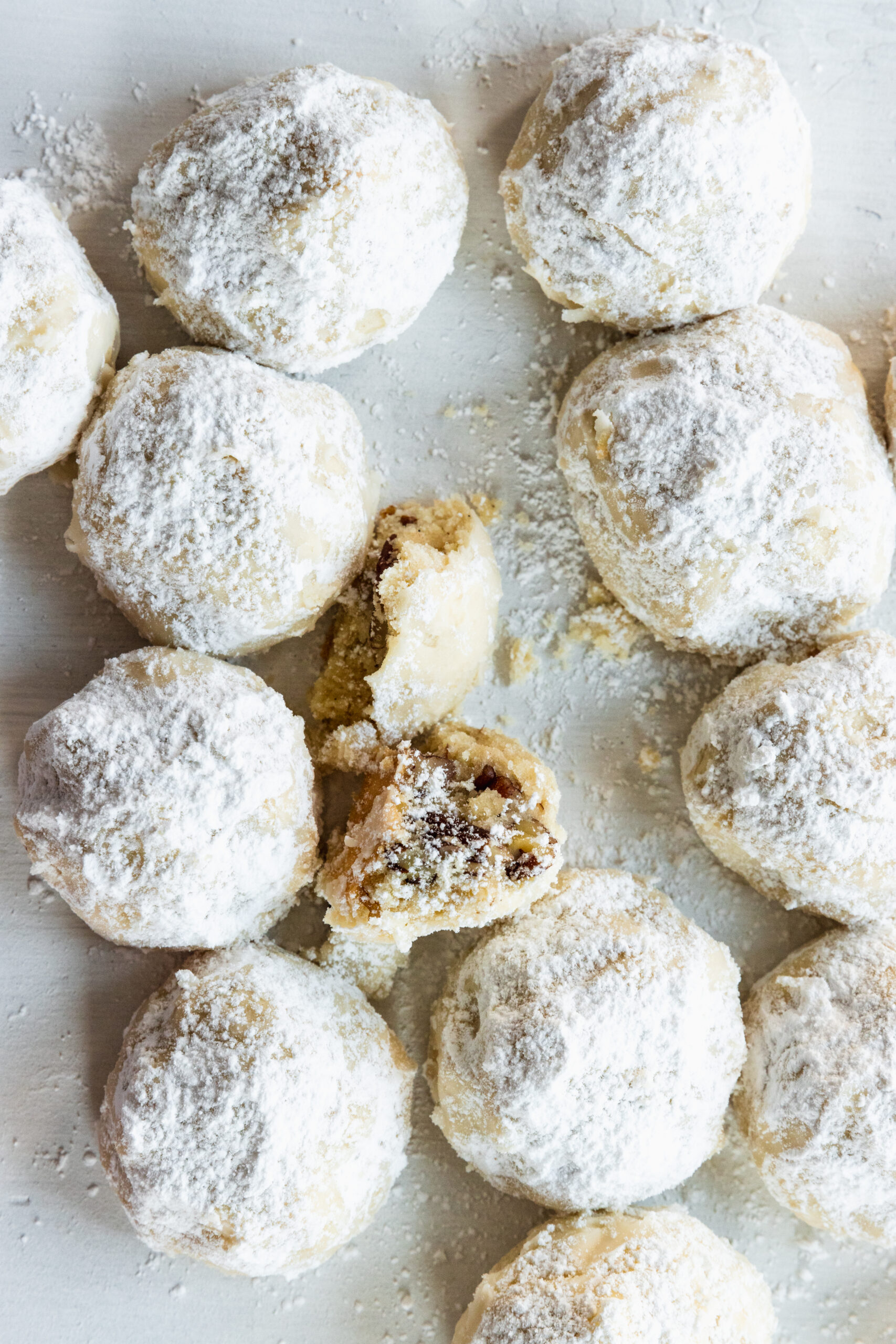 Vegan snowball cookies with one cookie broken in half