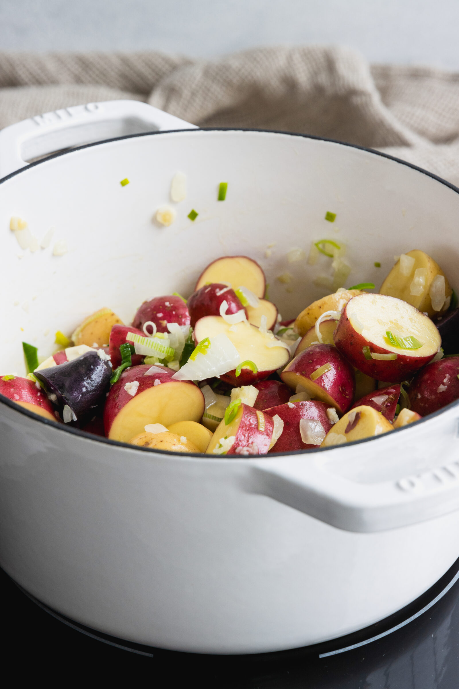 Onion, garlic, leek, parsnip, and potato sautéing in a pot