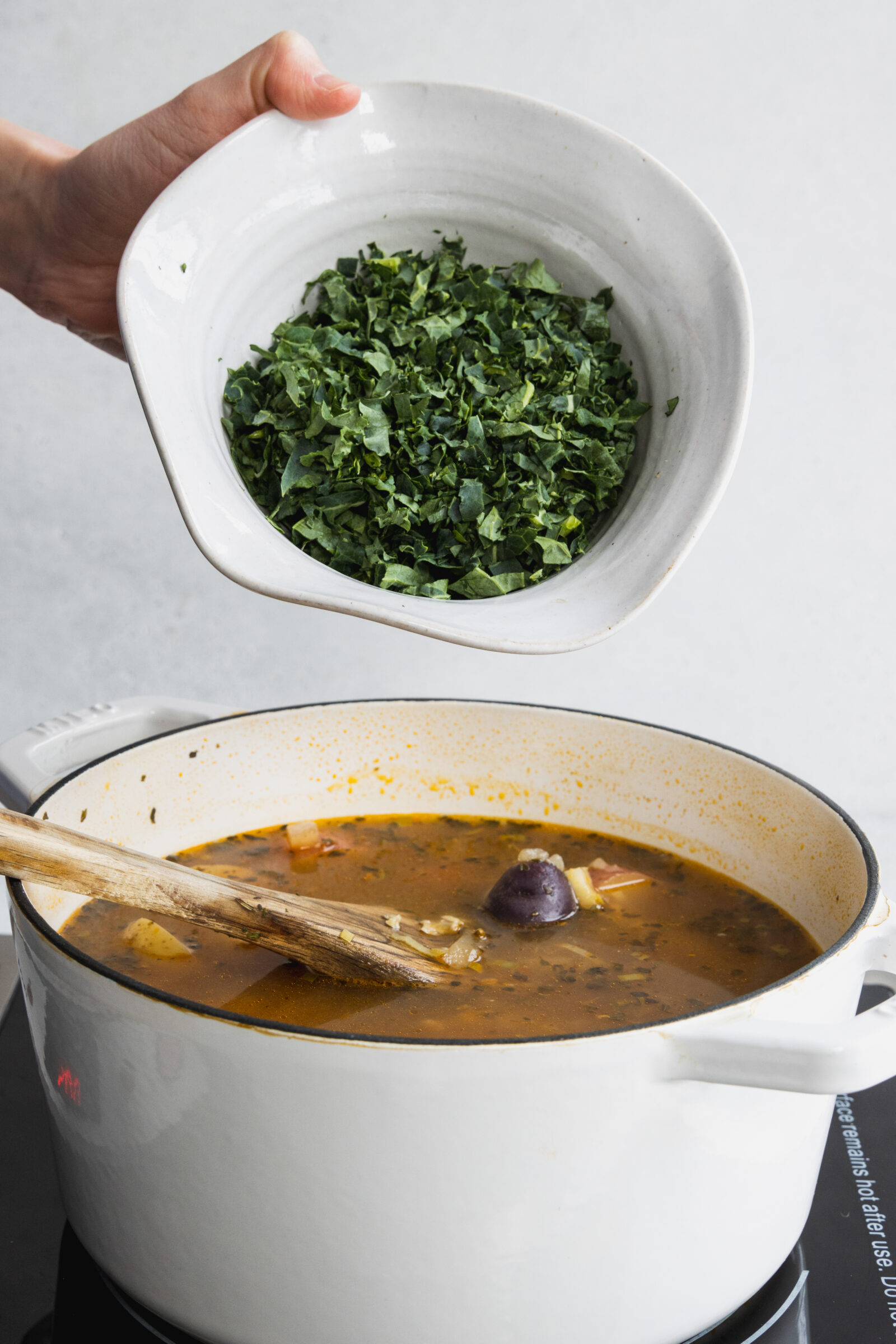 Adding the chopped kale to the soup