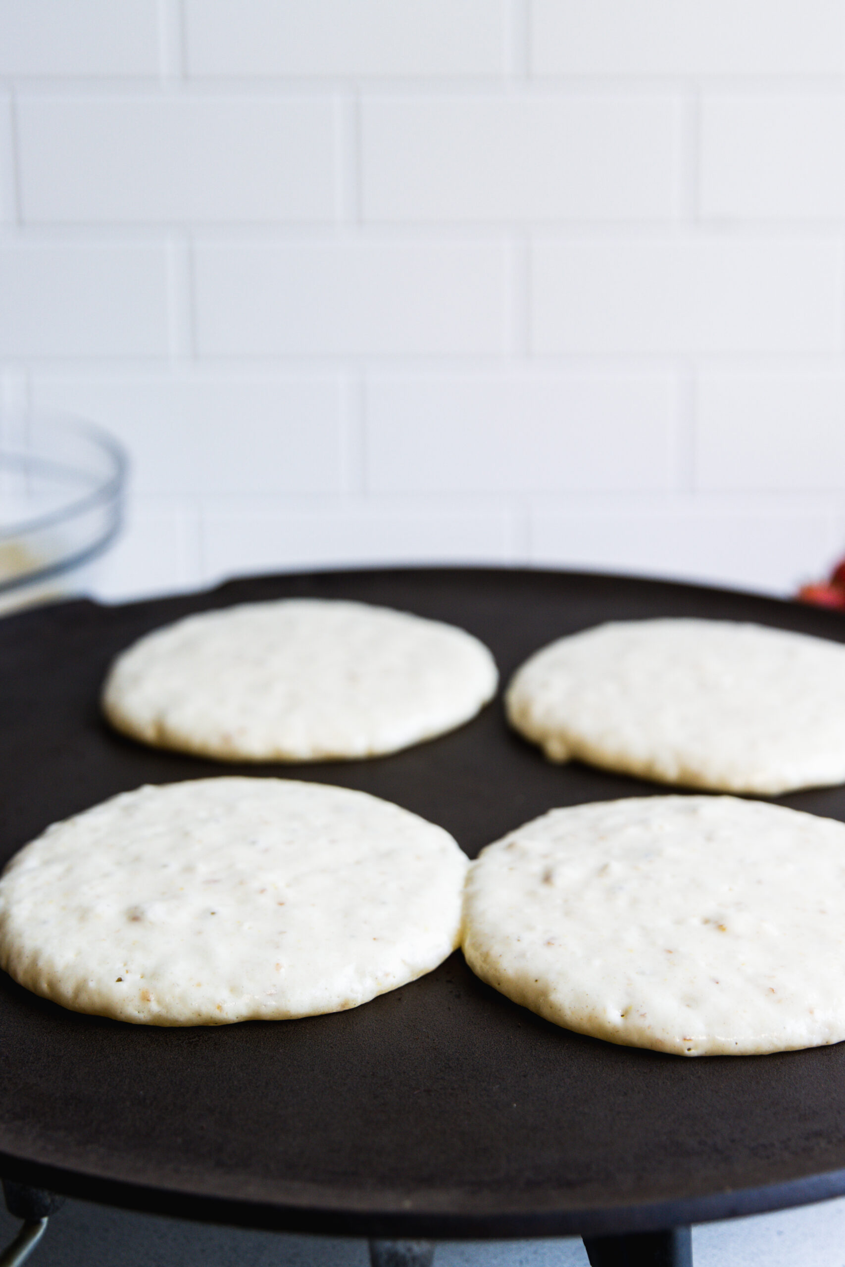 Fluffy Vegan pancakes cooking on a griddle