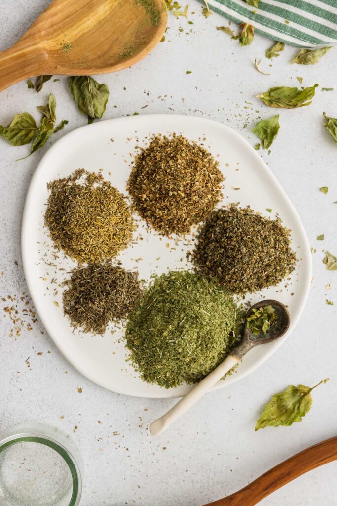 Herbs for Italian seasoning on a plate before mixing