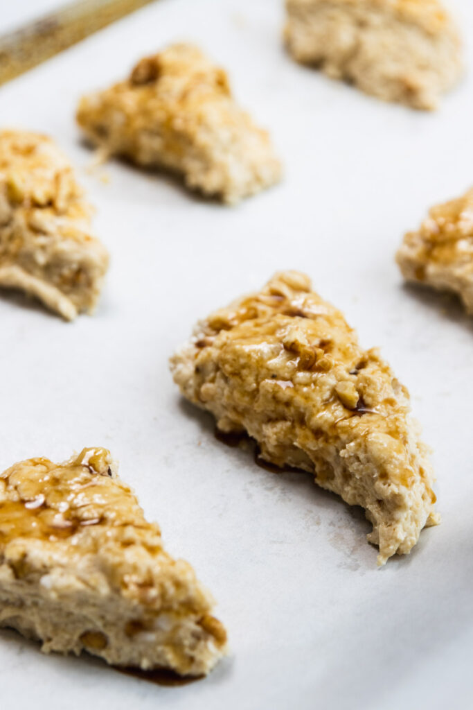 Walnut maple scones after brushing with maple syrup and sprinkling with more chopped walnuts