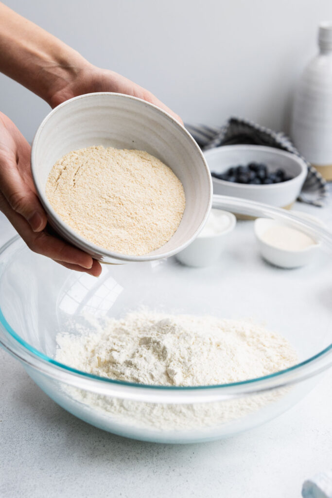 Adding whole wheat flour to a bowl