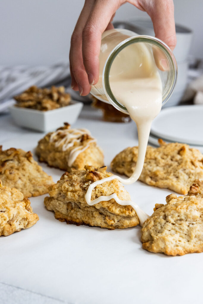 Pouring maple glaze over walnut scones