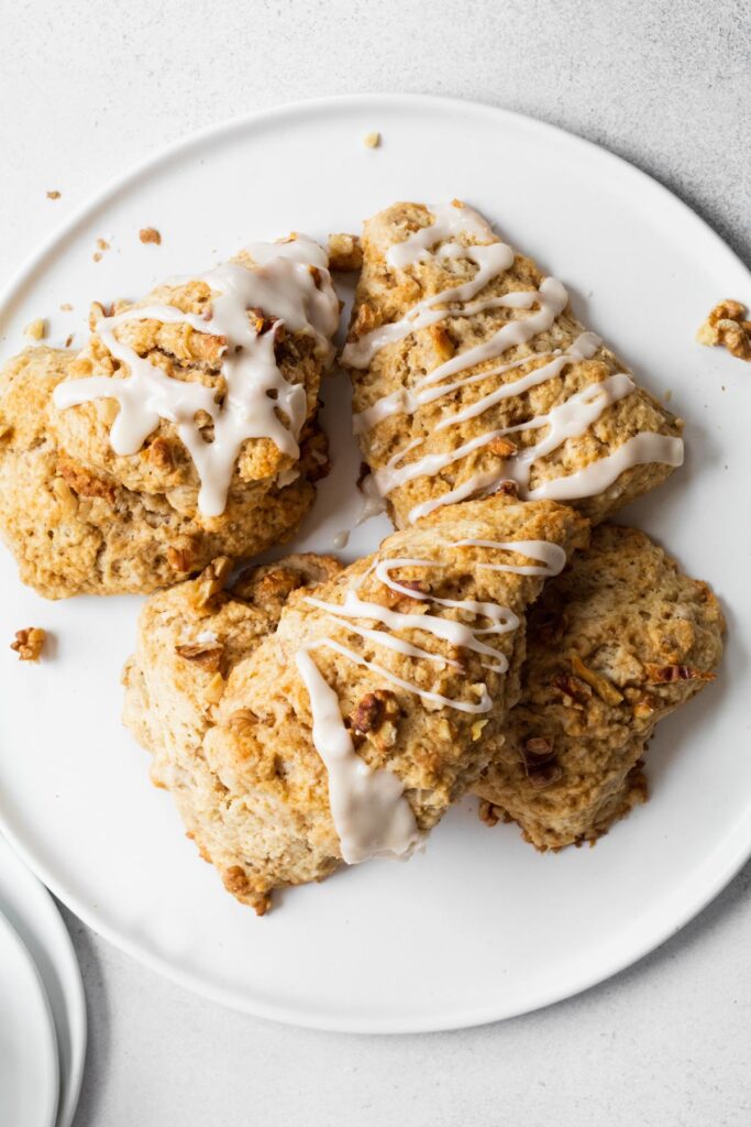 Walnut scones with maple glaze served on a white plate