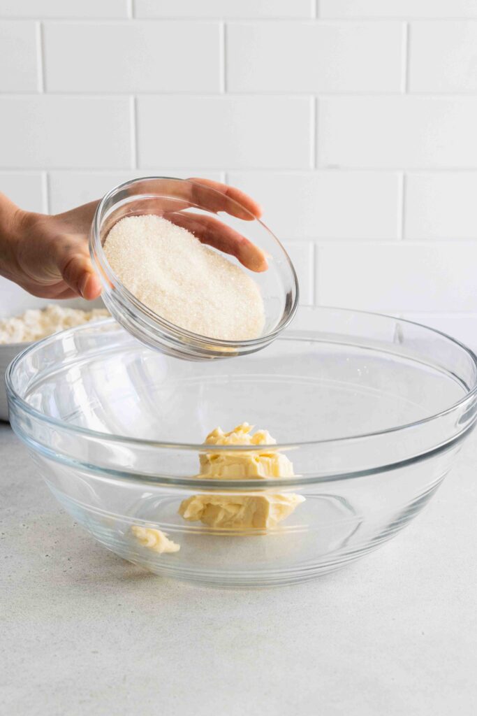 Adding margarine and sugar to a large glass bowl