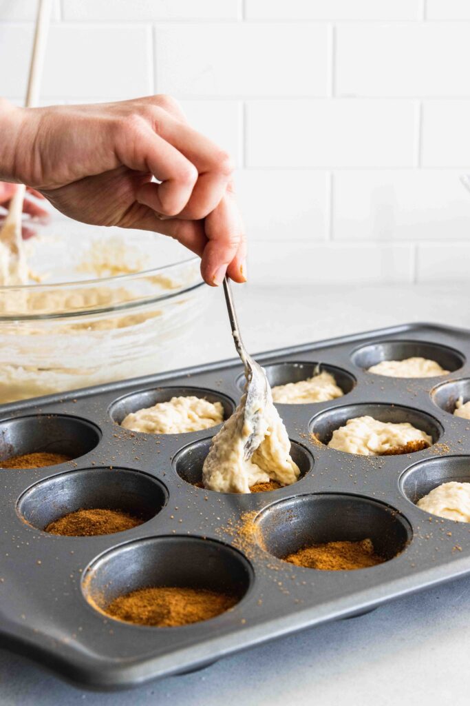 Adding a second layer of batter over the muffins