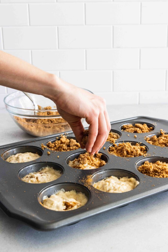 Sprinkling the cinnamon streusel over the muffins
