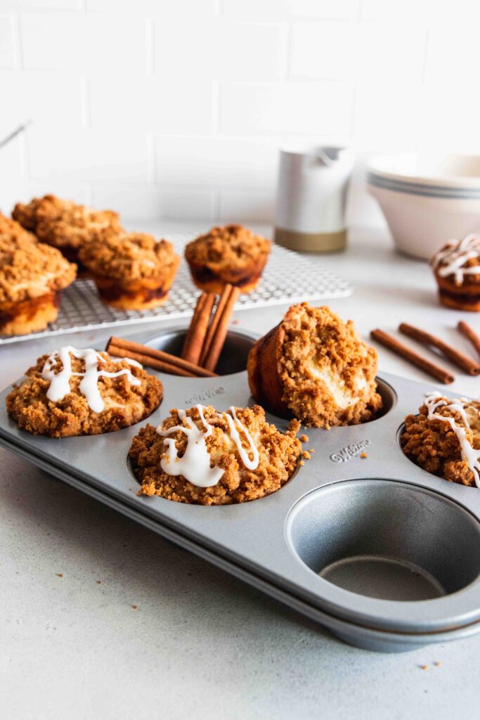 Coffee Cake muffins in a muffin tray with powder sugar glaze