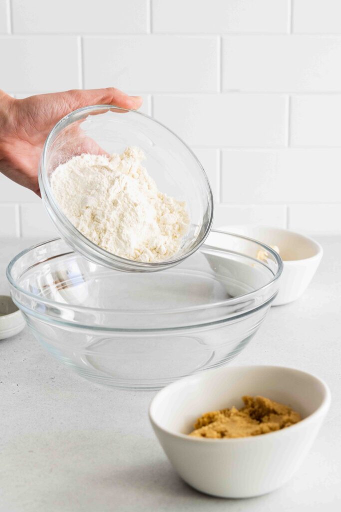 Adding flour to a glass bowl