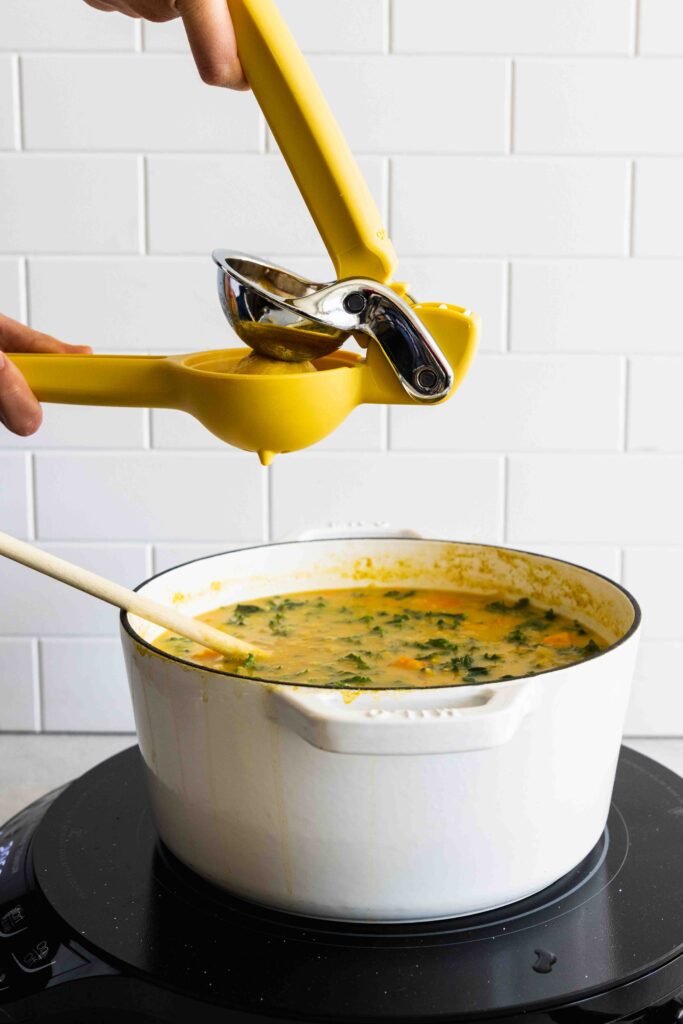 Squeezing fresh lemon juice into the soup