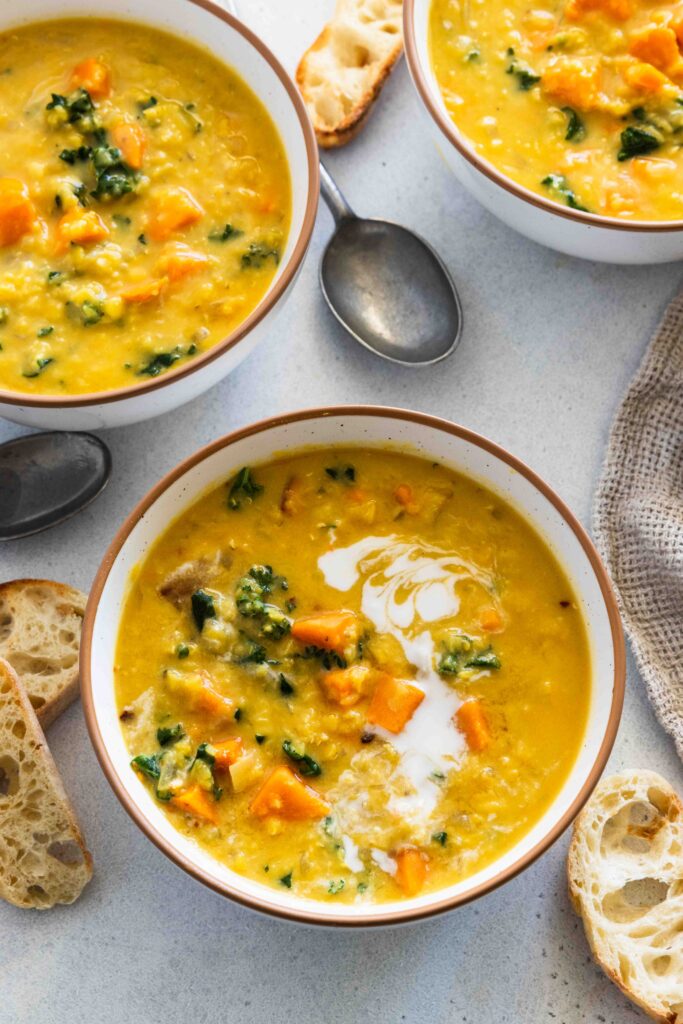 Red lentil soup served with a drizzle of coconut milk
