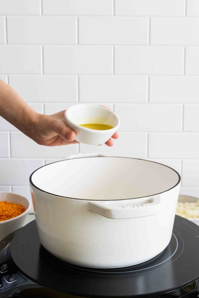 Adding olive oil to the pot