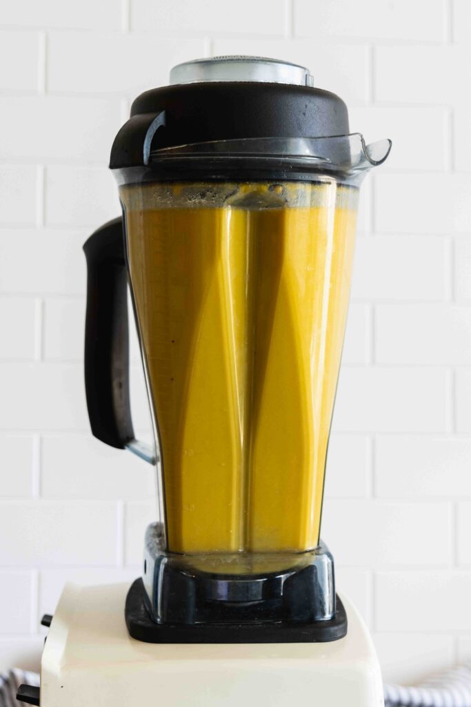 Blending the roasted butternut squash pasta sauce in a blender until smooth