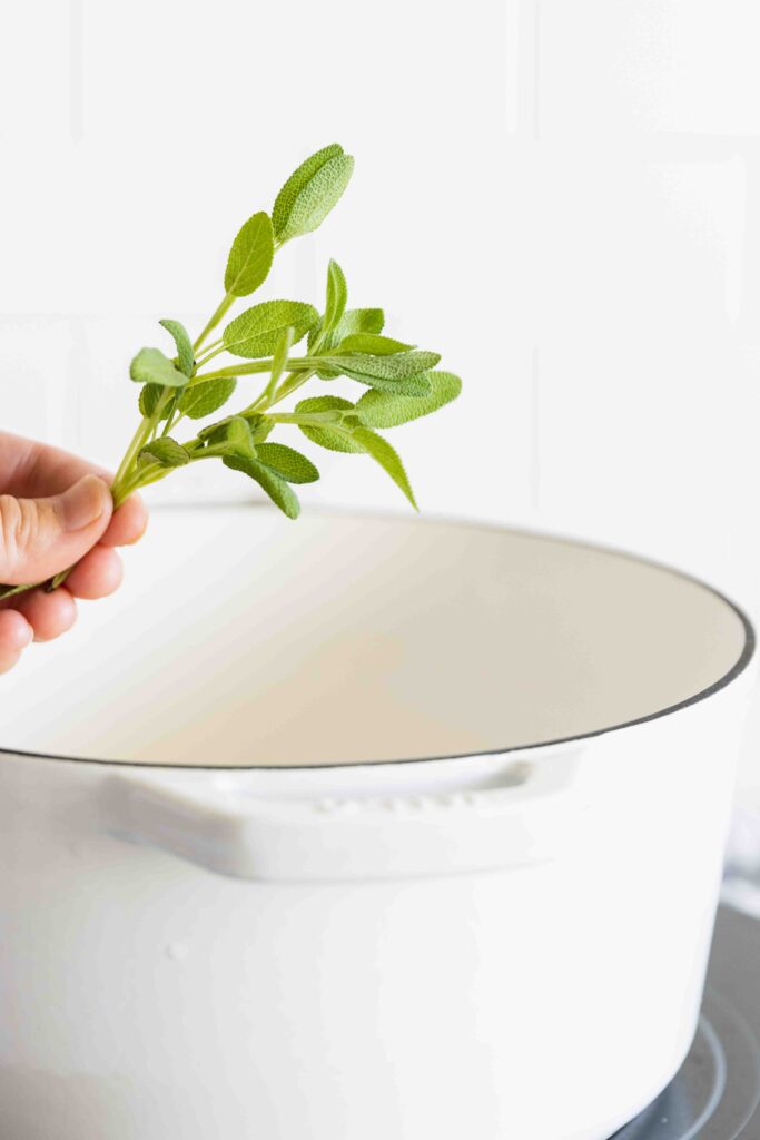 Adding fresh sage to a pot