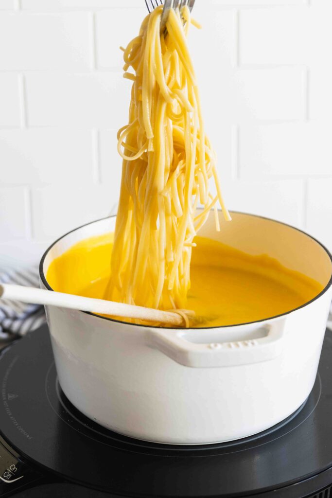 Tossing the roasted butternut squash sauce with pasta